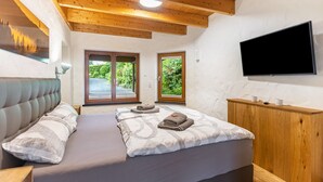 Ein Schlafzimmer mit einem Bett, einem Fernseher und einem Holzkopfteil.