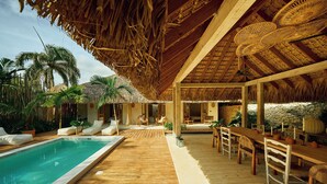 A wooden deck with a pool, lounge chairs, and a dining area with tables and chairs. - 7 BEDROOM BUNGALOW WITH POOL & A/C, NEAR MACAO BEACH (Punta Cana)