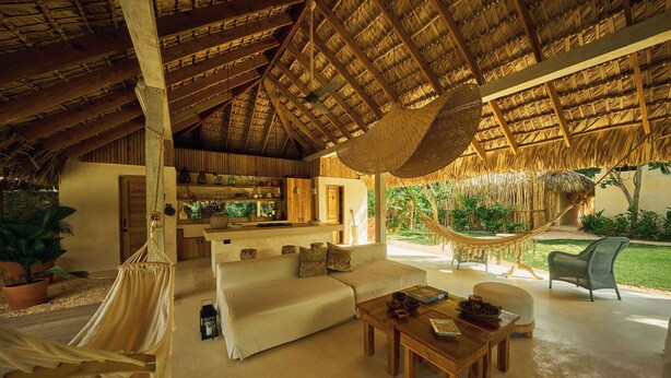 A spacious living area with a hammock, a sofa, and a coffee table. - 7 BEDROOM BUNGALOW WITH POOL & A/C, NEAR MACAO BEACH (Punta Cana)