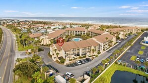 A coastal hotel with multiple buildings, a parking lot, and a view of the beach. - Ocean Villas Unit 118: Lagoon-Side Luxury with Direct Access (St. Augustine Beach)