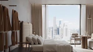 Ein modernes Hotelzimmer mit einem großen Bett, einem Schreibtisch und Blick auf eine Stadtansicht.