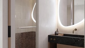 Ein modernes Badezimmer mit Marmorwaschbecken, einem großen Spiegel mit runder Beleuchtung und einer Duschkabine.