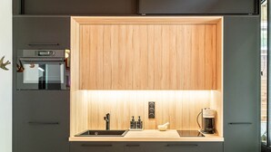 Eine moderne Küche mit Einbauofen, Spüle und Kaffeemaschine.