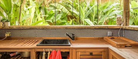 Una cocina con encimera de madera, un fregadero y un salpicadero con diseño de panal.