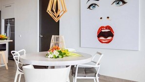 A modern dining area with a round table, white chairs, and a decorative centerpiece. - Stylish sea-view apartment with sunset terrace - Coral Estate (Sint Willibrordus)