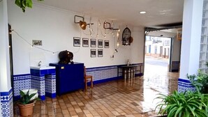 Een receptie met een blauwe balie, betegelde vloer en wanddecoraties.
