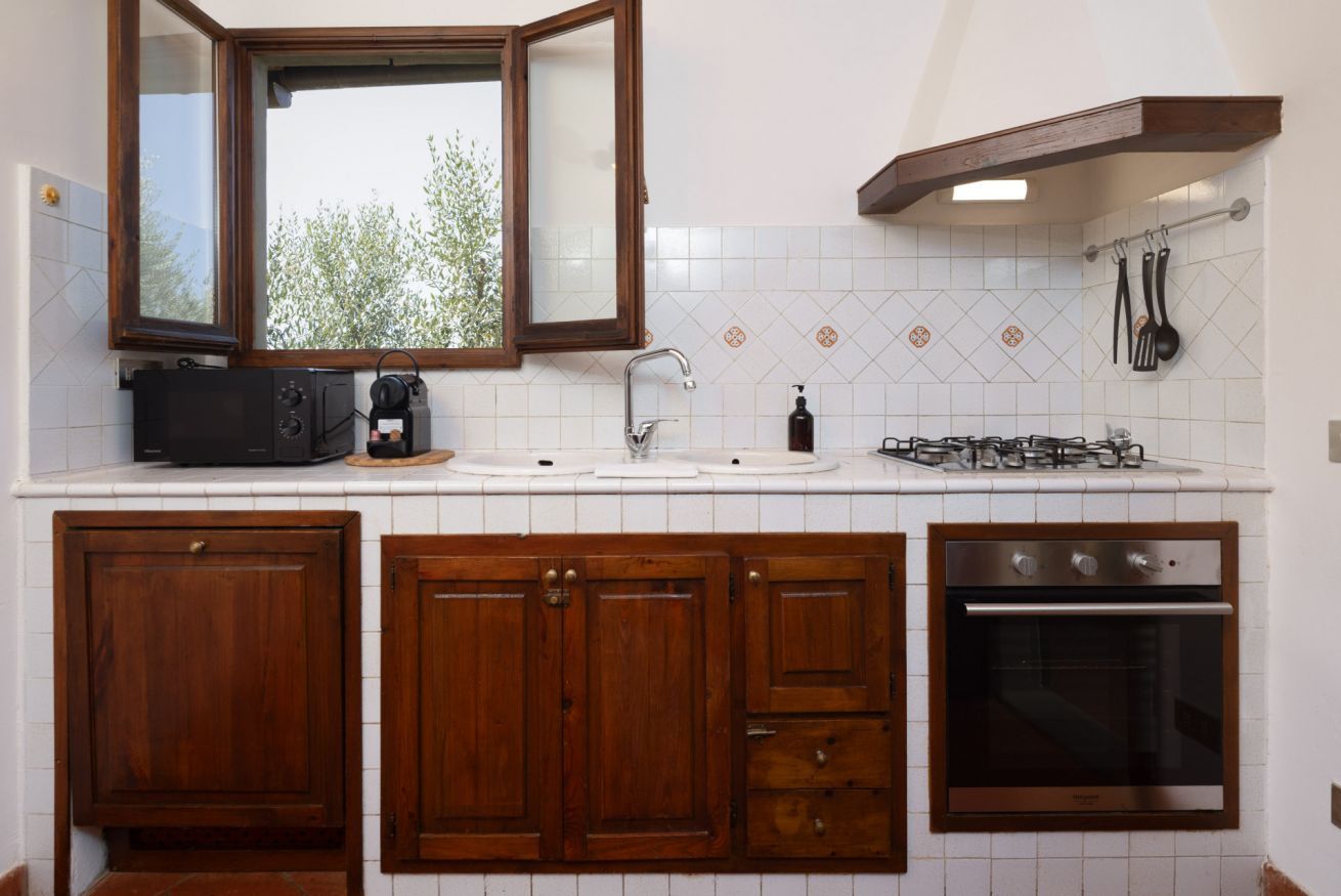 A kitchen with wooden cabinets, a built-in oven, a microwave, and a gas stove.