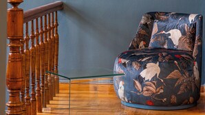 A room with a blue wall, a wooden staircase, and a floral-patterned armchair. - Iliotropio Athens, Thisio (Athens)