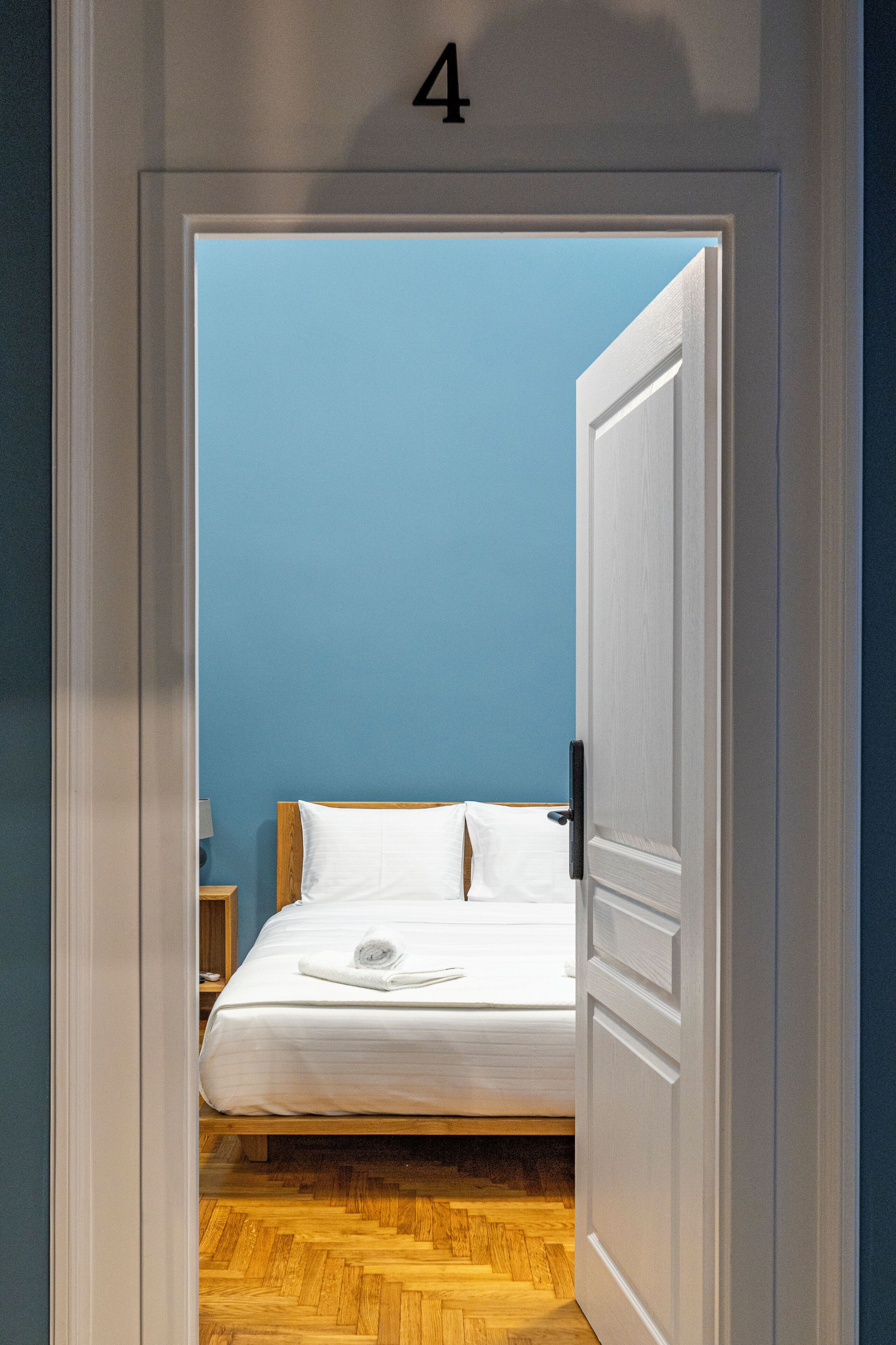 Un dormitorio con una cama, una mesita de noche y una pared con un número.