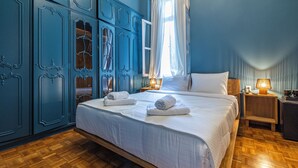 A bedroom with a large bed, wooden flooring, and blue cabinetry. - Iliotropio Athens, Thisio (Athens)