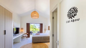 Une chambre moderne avec un lit, une télévision, un bureau et un balcon.