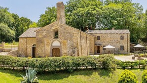 A stone building with a central arched doorway, a chimney, and a smaller attached structure with windows and a door. - Villa of approximately 150 m2 located on the ground floor and on two levels with air conditioning, independent heating and wi fi line.Composed of a large living room with independent equipped kitchen, fridge, microwave oven, toaster, sofa and satellite t (Sorano)