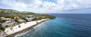 A coastal property with a beach, ocean view, and multiple buildings. - Spacious villa with infinity pool and ocean view (Sint Willibrordus)