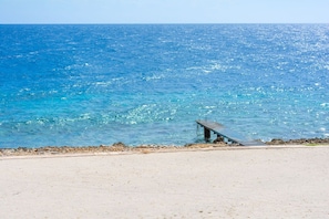 Ein Strand mit einer Betonbank mit Blick auf den Ozean.