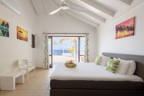 Une chambre d’hôtel avec un lit, un bureau et une vue sur la plage.