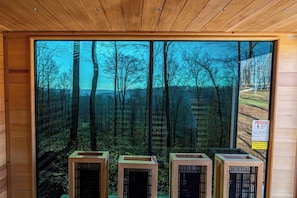 A room with large windows offering a view of a forest. There are three air conditioning units in front of the windows. - Waterfront Cabin w/ Sauna near French Lick, IN (Shoals)