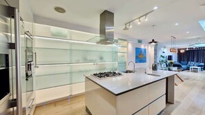 Eine moderne Küche mit Kochinsel, eingebauten Geräten und einem Schrank mit Glastür.