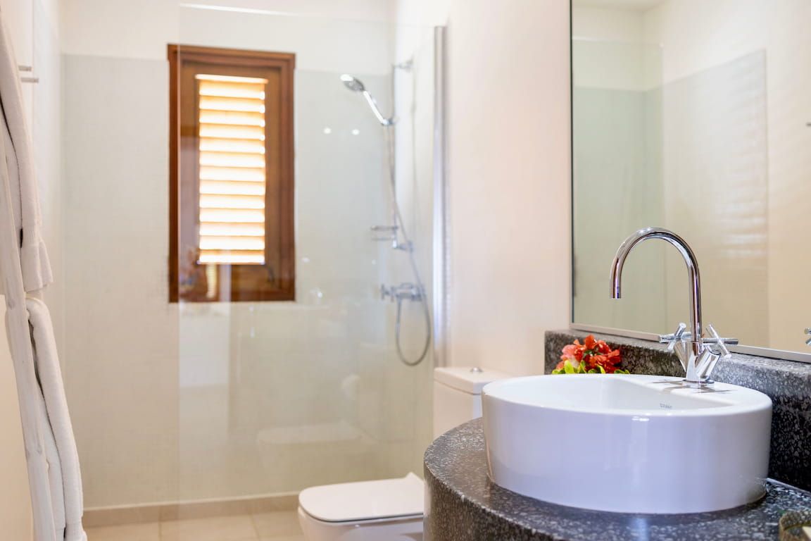 A bathroom with a white sink, a glass shower enclosure, and a toilet.