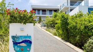 Un camino que lleva a un edificio moderno con un cartel que muestra una escena costera y el número 537.