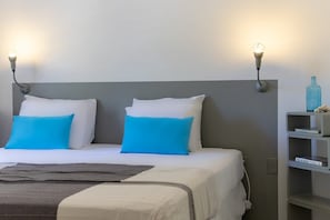 A hotel room with a bed, two wall-mounted lamps, a shelf with books, and a power outlet. - Panoramic sea-view villa with private pool (Sint Willibrordus)