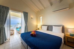 Ein Hotelzimmer mit einem großen Bett, einem Balkon mit Blick und einem Deckenventilator.