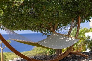 A hammock under a tree with a view of the ocean. - Modern sea-view villa with private infinity pool (Sint Willibrordus)