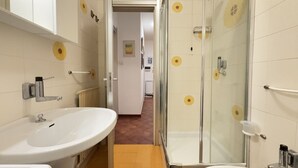 Ein Badezimmer mit Waschbecken, Spiegel, Dusche und Toilette.