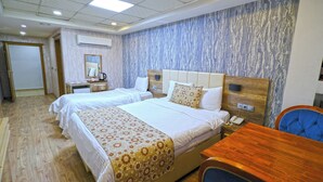 A hotel room with two beds, a desk, a chair, a coffee maker, and a phone. - Divanyolu Otel (Şanlıurfa)