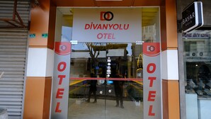 The entrance to Divanyolu Hotel with a glass door and a sign above. - Divanyolu Otel (Şanlıurfa)