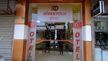 La entrada del Hotel Divanyolu, con una puerta de vidrio y un letrero en la parte superior.