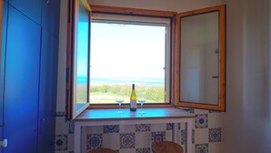Ein Eckzimmer mit Fenster, einer Flasche und zwei Gläsern auf dem Fensterbrett.