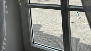 A window with a view of a courtyard, a statue, and a building with arched windows. - Apartment 'Richard W, 90 sqm' in Weimar – up to 8 adults (Weimar)