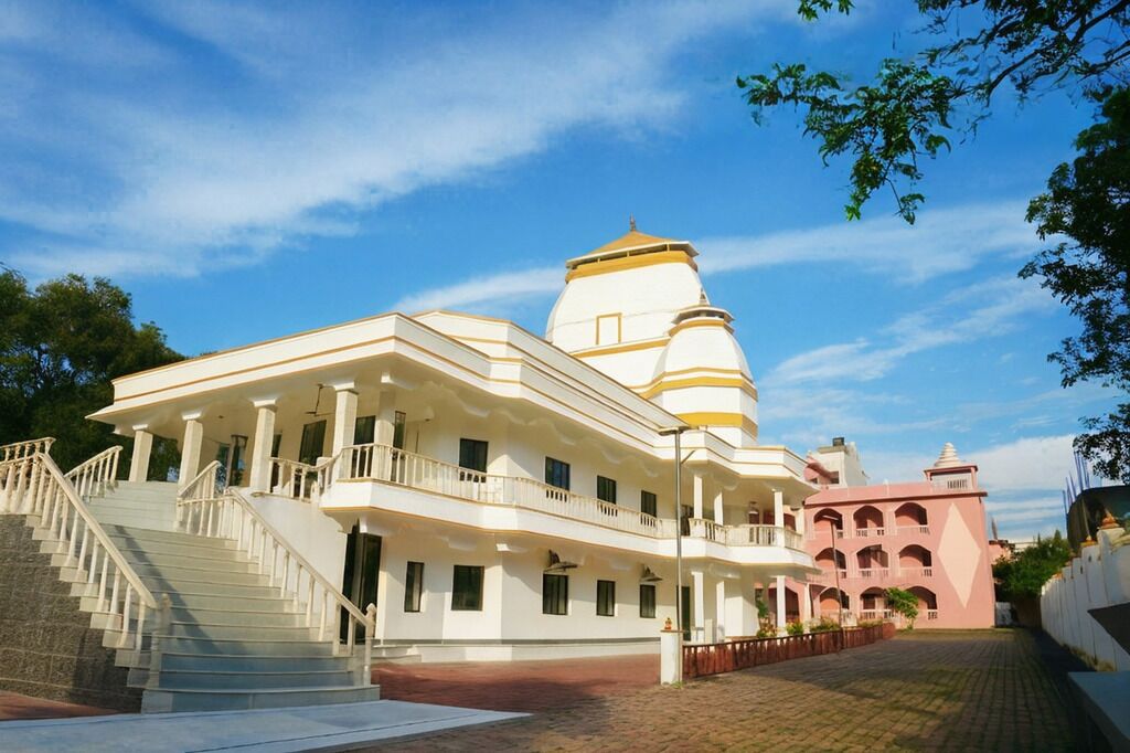 A building with a central dome, a staircase leading to the entrance, and a smaller adjacent structure.