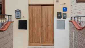 A wooden door with a mailbox and a blue sign on the wall.