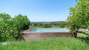 A swimming pool surrounded by a wooden deck, with a view of a rural landscape. - Casa Lounell: Pool, Spa, Sauna & Games Room in the Tarn Countryside (Graulhet)