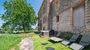A stone building with a patio area, outdoor seating, and a hot tub. - Casa Lounell: Pool, Spa, Sauna & Games Room in the Tarn Countryside (Graulhet)