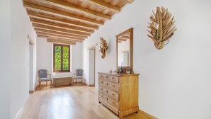 A spacious room with wooden flooring, a wooden dresser, a mirror, and a decorative wall piece. - Casa Lounell: Pool, Spa, Sauna & Games Room in the Tarn Countryside (Graulhet)