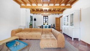 A living room with a sectional sofa, a coffee table, and a dining area with a table and chairs. - Casa Lounell: Pool, Spa, Sauna & Games Room in the Tarn Countryside (Graulhet)