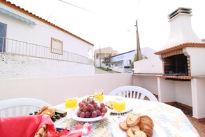 A dining table with plates of food, glasses of orange juice, and a croissant. - Villa GrandVale (Castro Marim)