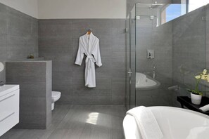 A modern bathroom with a glass shower enclosure, a white bathtub, and a white toilet. - Penthouse Apt Historic Charm Incredible Views (Cape Town)