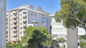 A multi-story residential building with balconies, surrounded by greenery and a clear sky. - Charming Central Sea Point Haven 50m to Ocean (Cape Town)