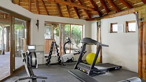 A gym with cardio equipment, a treadmill, and a stationary bike. - Modern Sea Point Oasis Garden Pool BBQ Gym (Cape Town)