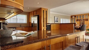 Een moderne keuken met granieten aanrechtbladen, houten keukenkastjes en een inbouw eiland.