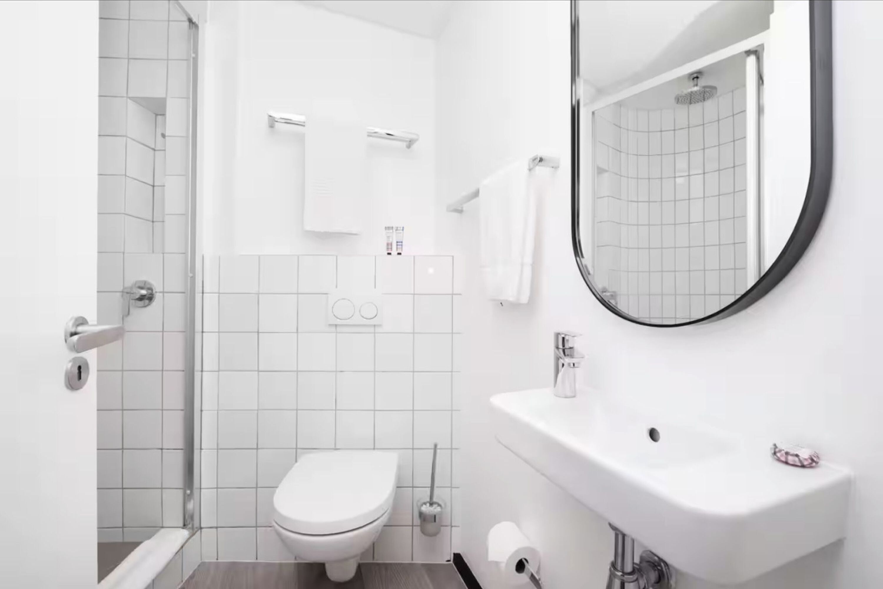 A modern bathroom with a toilet, sink, and shower.