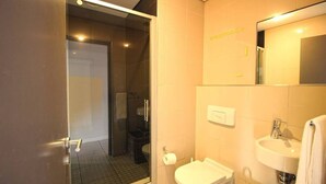 A modern bathroom with a glass shower enclosure, a toilet, and a sink. - Upmarket 2bed City Retreat Close to V A Waterfront (Cape Town)