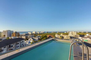 A rooftop swimming pool with a view of the cityscape and the sea. - Secure 2bed Green Point Retreat Rooftop Pool BBQ (Cape Town)