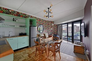Una cocina compacta con zona de comedor, un ventanal y vistas a edificios.