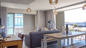 Een moderne woonkamer met een bank, een houten tafel en een wereldbol op een bureau.