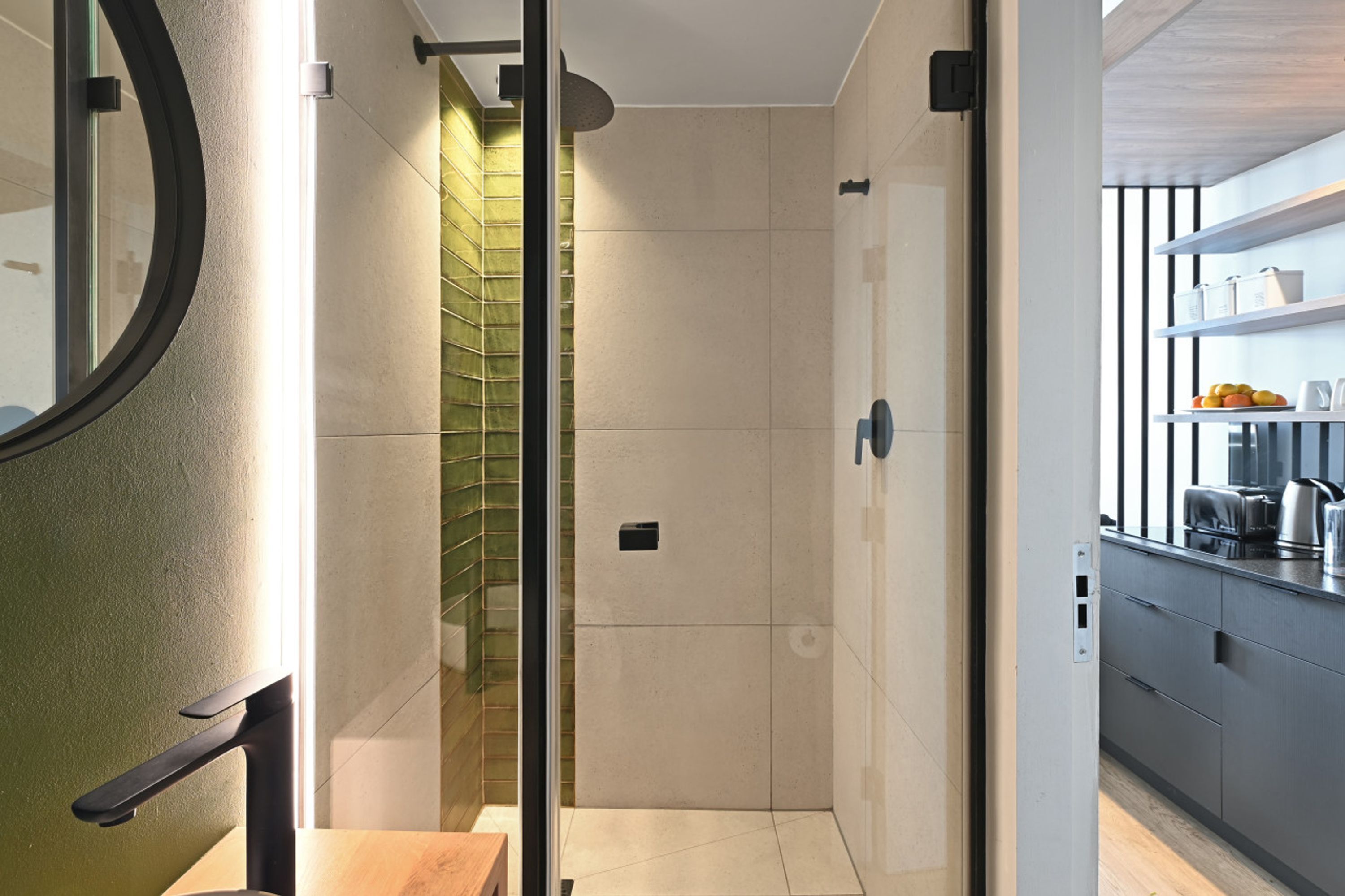Une salle de bain moderne dotée d’une douche à parois de verre, de toilettes et d’un lavabo avec un plan de travail.