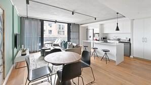 A modern apartment with a dining area, kitchen, and living space. - Two Bedroom Green Point Rooftop Pool BBQ (Cape Town)